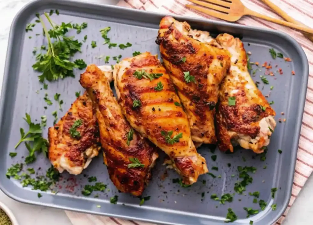 This image showcases a delicious serving of golden-brown baked turkey wings, perfectly seasoned and garnished with fresh parsley. The wings have a crispy, caramelized skin with visible grill