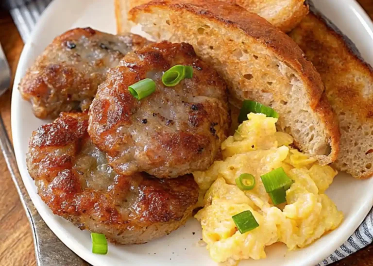 A breakfast of beef breakfast sausage, eggs, and toast served on a white plate with a sprinkling of parsley.