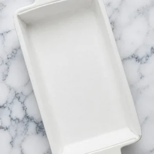 Empty white ceramic loaf pan lined with clean parchment paper