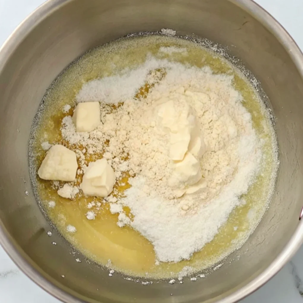 In a metal pot, melt the butter cubes until they become a clear liquid, then add the flour and stir.