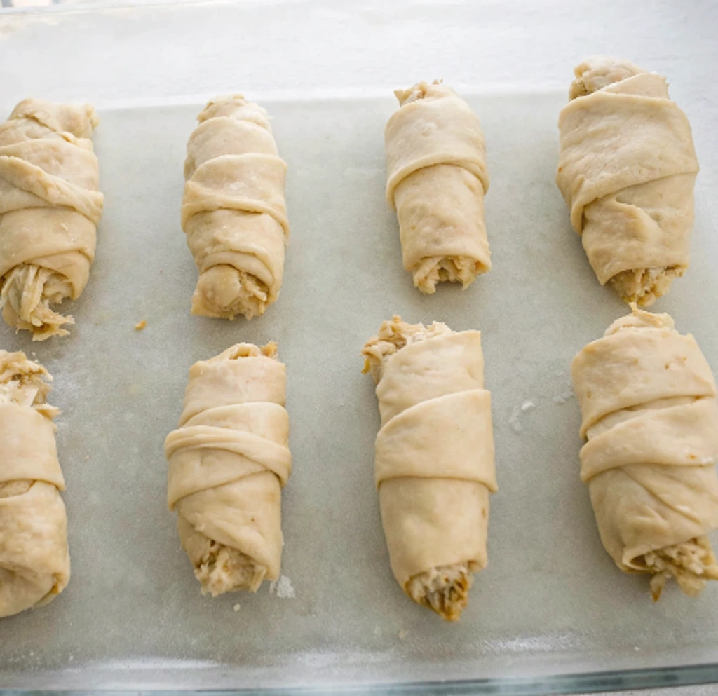 Crescent rolls stuffed with cheese and chicken, ready to bake