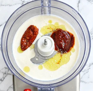 A mixture containing a “Ranch” mayonnaise base, crème fraîche, fromage blanc, chipotle pepper, adobo sauce, and lemon juice, ready to be mixed on a marble countertop.