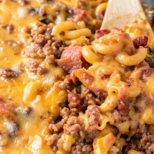 cheesy bacon cheeseburger casserole featuring elbow macaroni, savory ground beef, and crispy bacon bits smothered in a rich, melted cheddar cheese sauce and diced tomatoes.