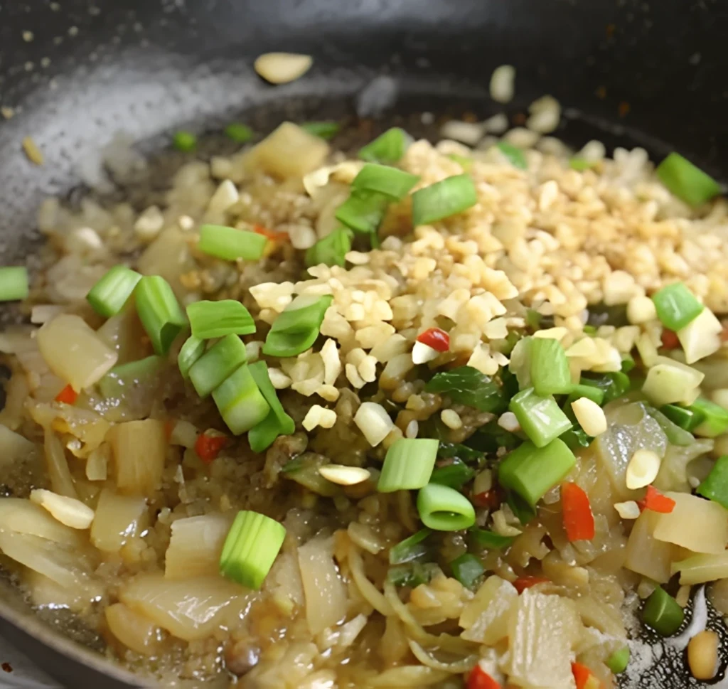 A mixture of chopped onion, minced garlic, and parsley is sautéed in a pan with a little red pepper to form the aromatic base for this Southern seafood sauce recipe.