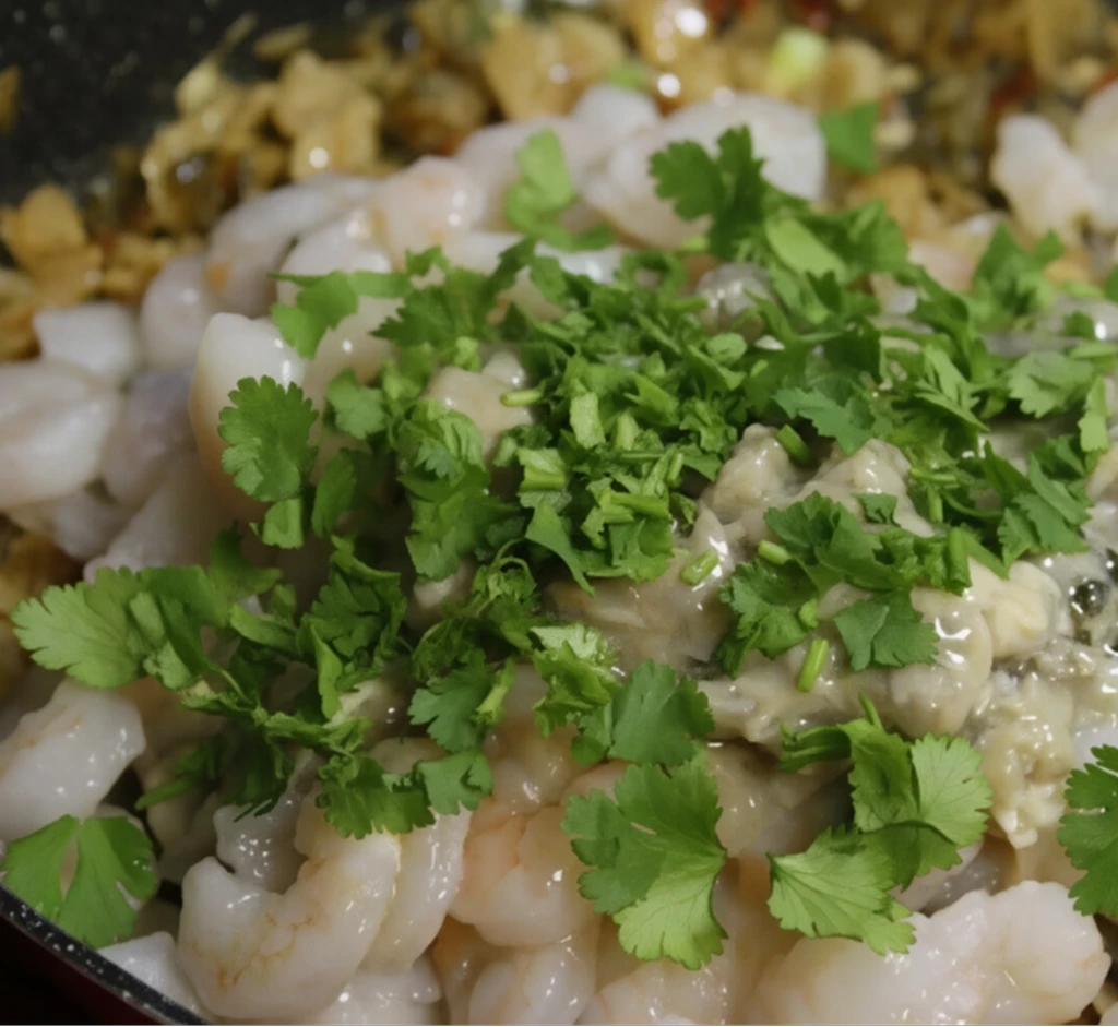 Add the fresh shrimp and clams to the pan with the onions, tomatoes, and butter, and top with chopped green parsley. Now it's ready to add to the Southern seafood sauce.